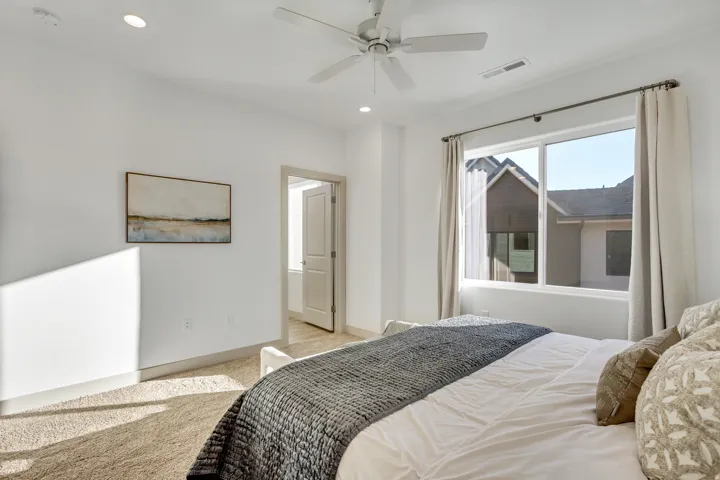 Recessed lighting, ceiling fan, expansive window, neutral wall paint, and light-toned carpet flooring