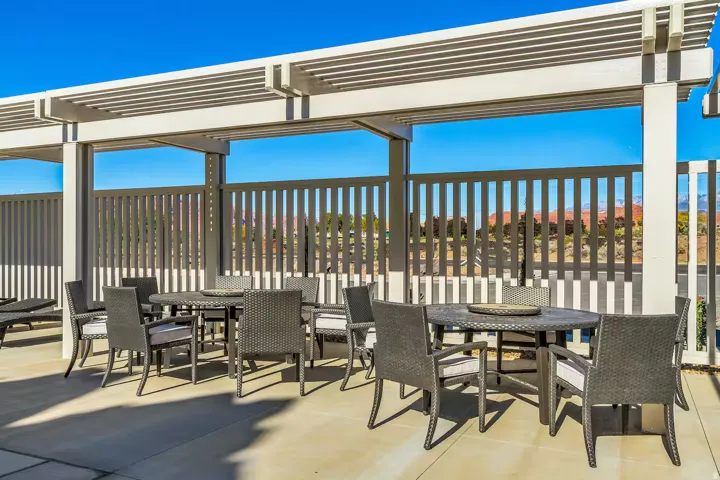 Expansive covered patio featuring a slatted pergola, concrete flooring, and privacy fencing