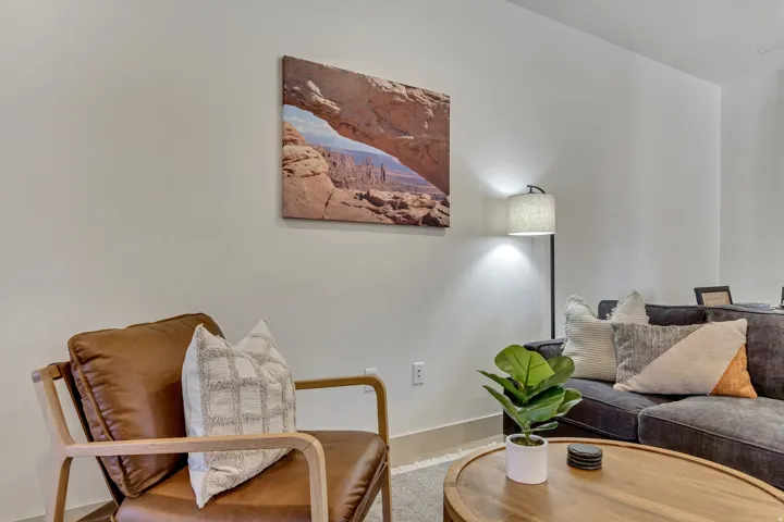 Recessed lighting and a floor lamp illuminate the space, complemented by light-toned wall paint and an accent wall