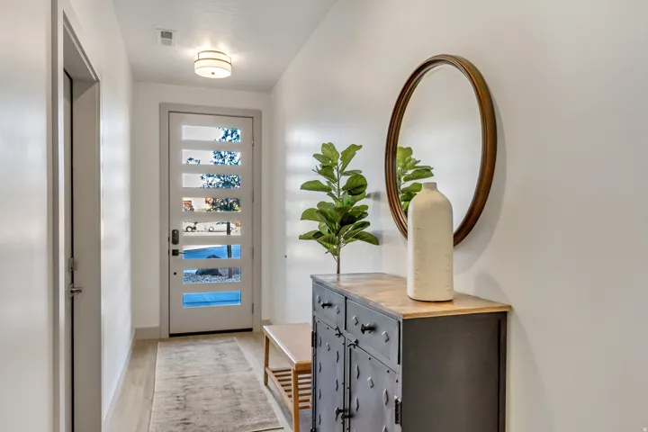 Entryway featuring wood-finish flooring, a contemporary flush mount light fixture, and a modern front door with horizontal lites