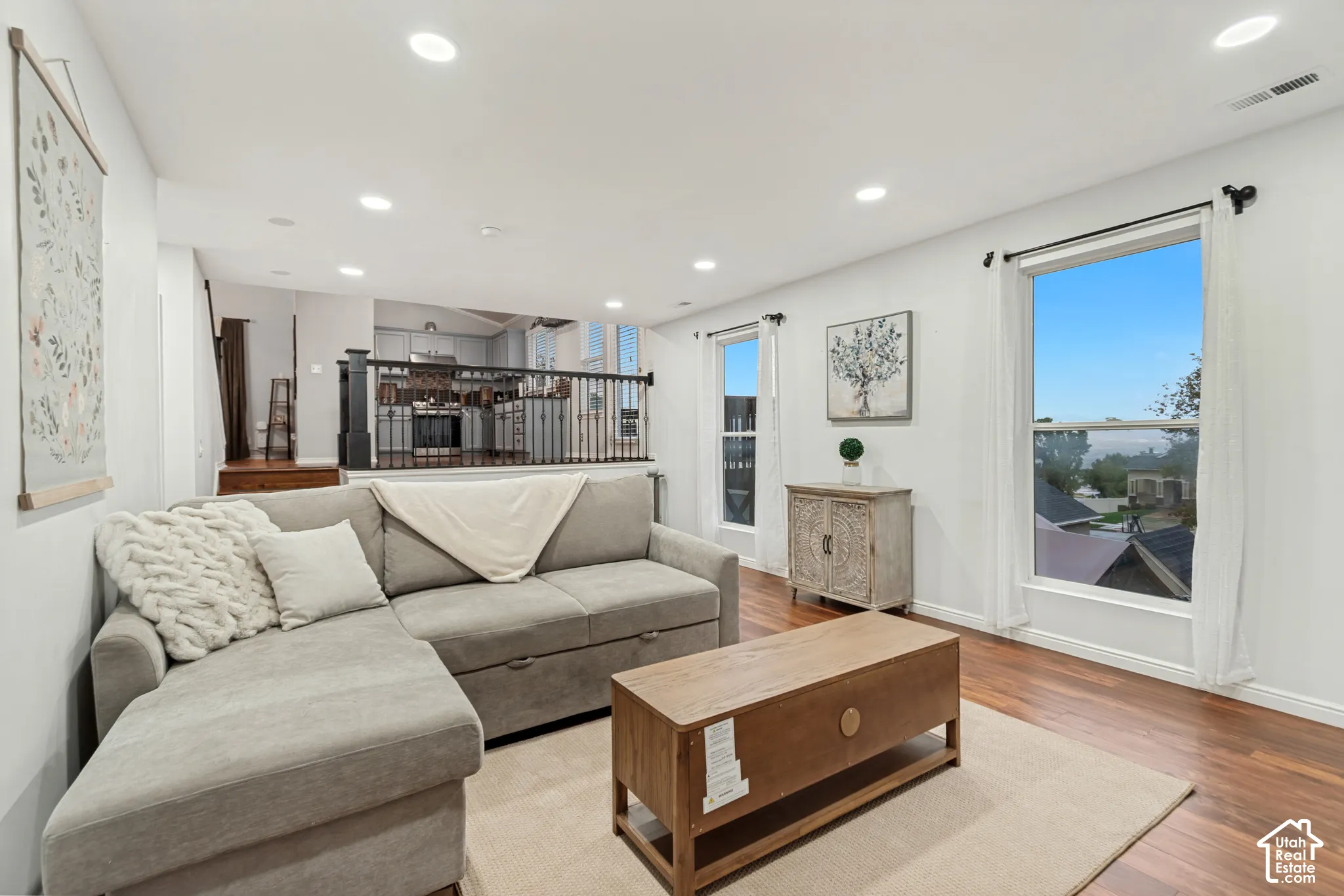 Living area featuring wood-finish flooring, recessed lighting, and vertical windows