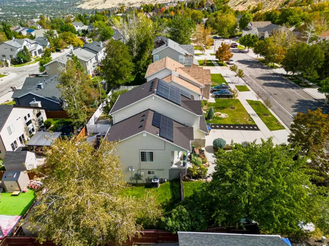 Contemporary residential architecture with solar panel array, landscaped front yard, and an established street