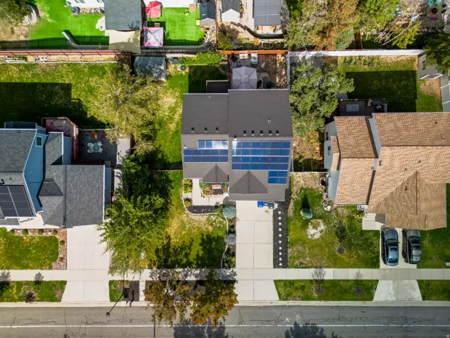Solar panel array, paved driveway, landscaped front yard, paved patio, asphalt shingle roof