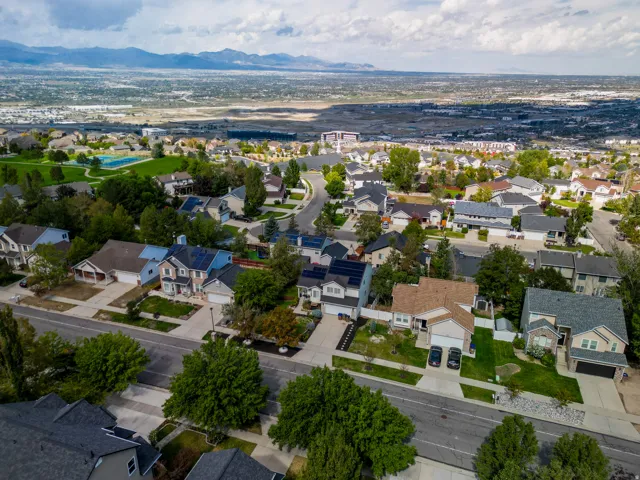 Residential neighborhood featuring a variety of single-family homes, mature trees, and a nearby community park with a sports court
