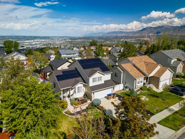 Residence with multiple solar panel arrays, attached garage, and a landscaped front yard