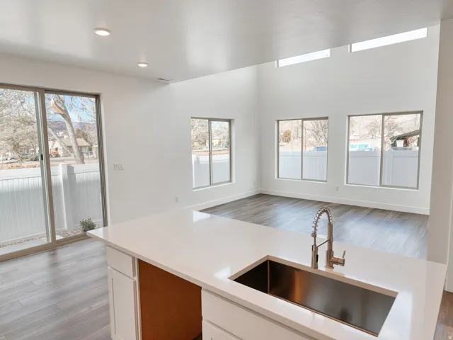 Spacious open-concept living area featuring high ceilings, recessed lighting, and wood-finish flooring