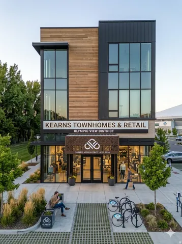 Contemporary multi-story building featuring expansive glass windows, wood paneling, and dark metal siding