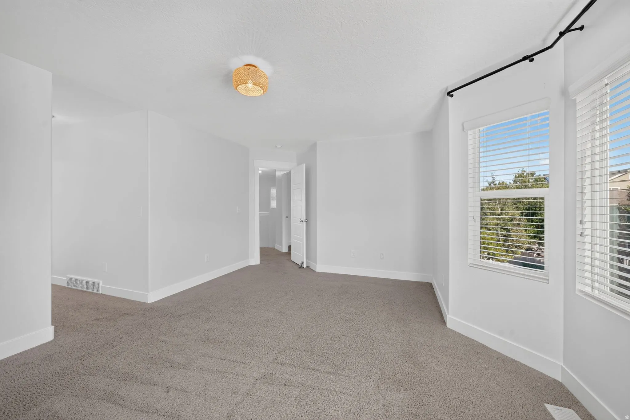 Recessed window bay with multiple windows, neutral carpet flooring, contemporary flush mount lighting, and white trim