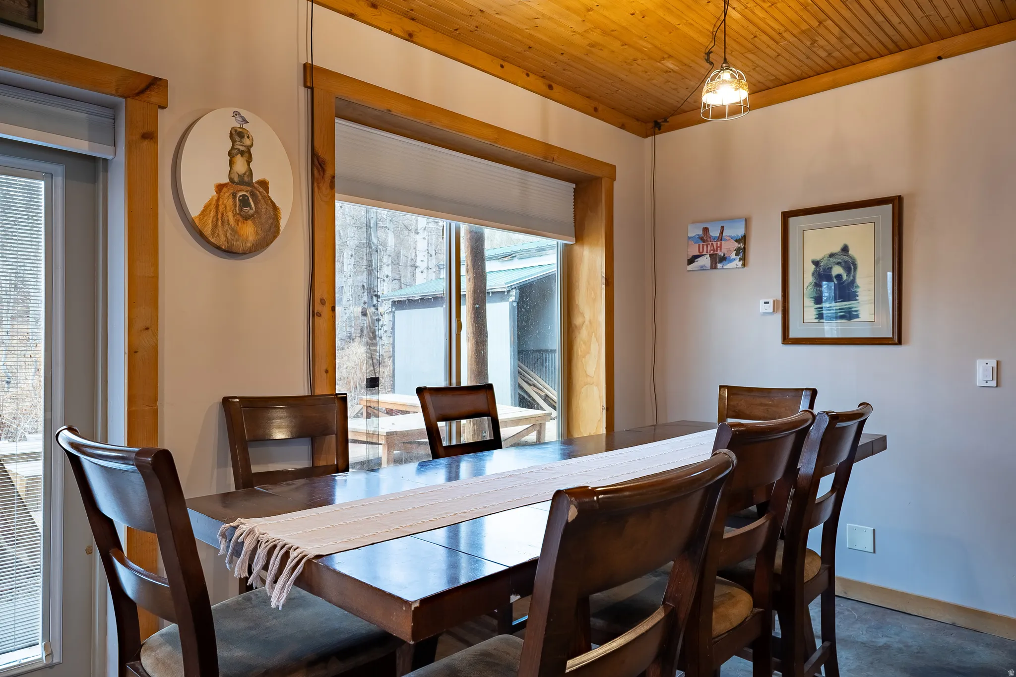 Wood-paneled ceiling with an industrial-style pendant light fixture