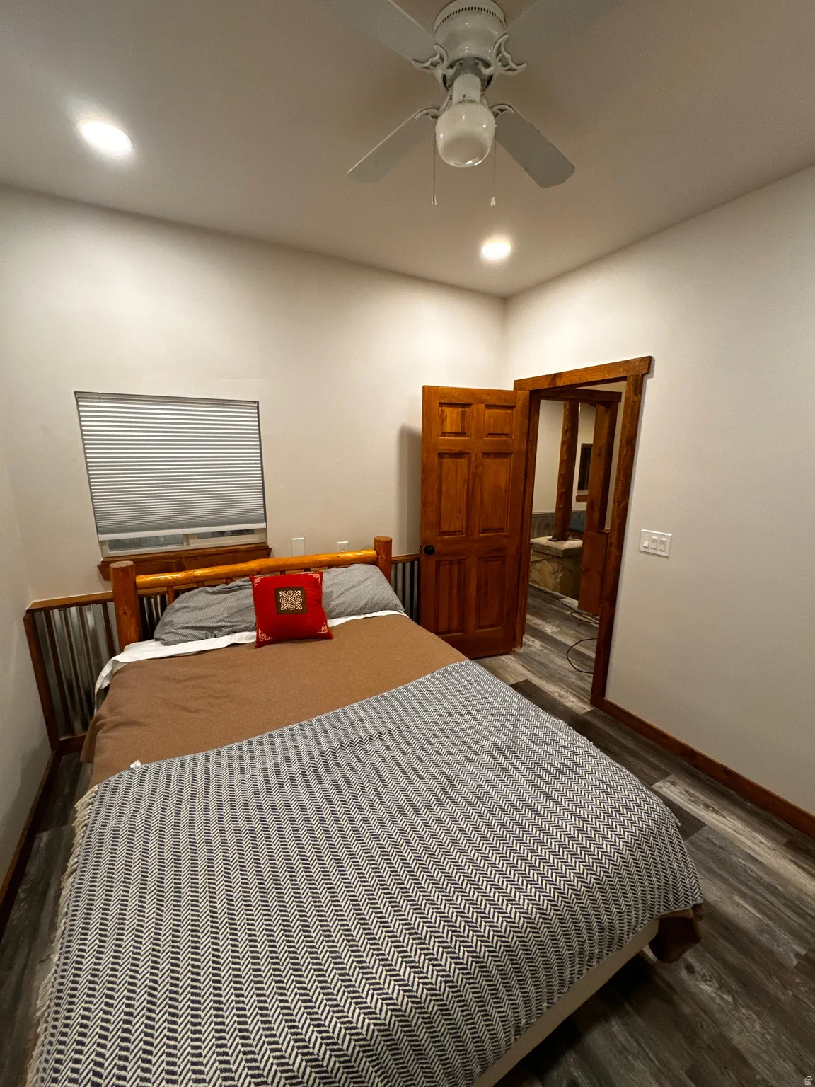 Wood-finish flooring, recessed lighting, ceiling fan, solid wood panel door, and window with blinds