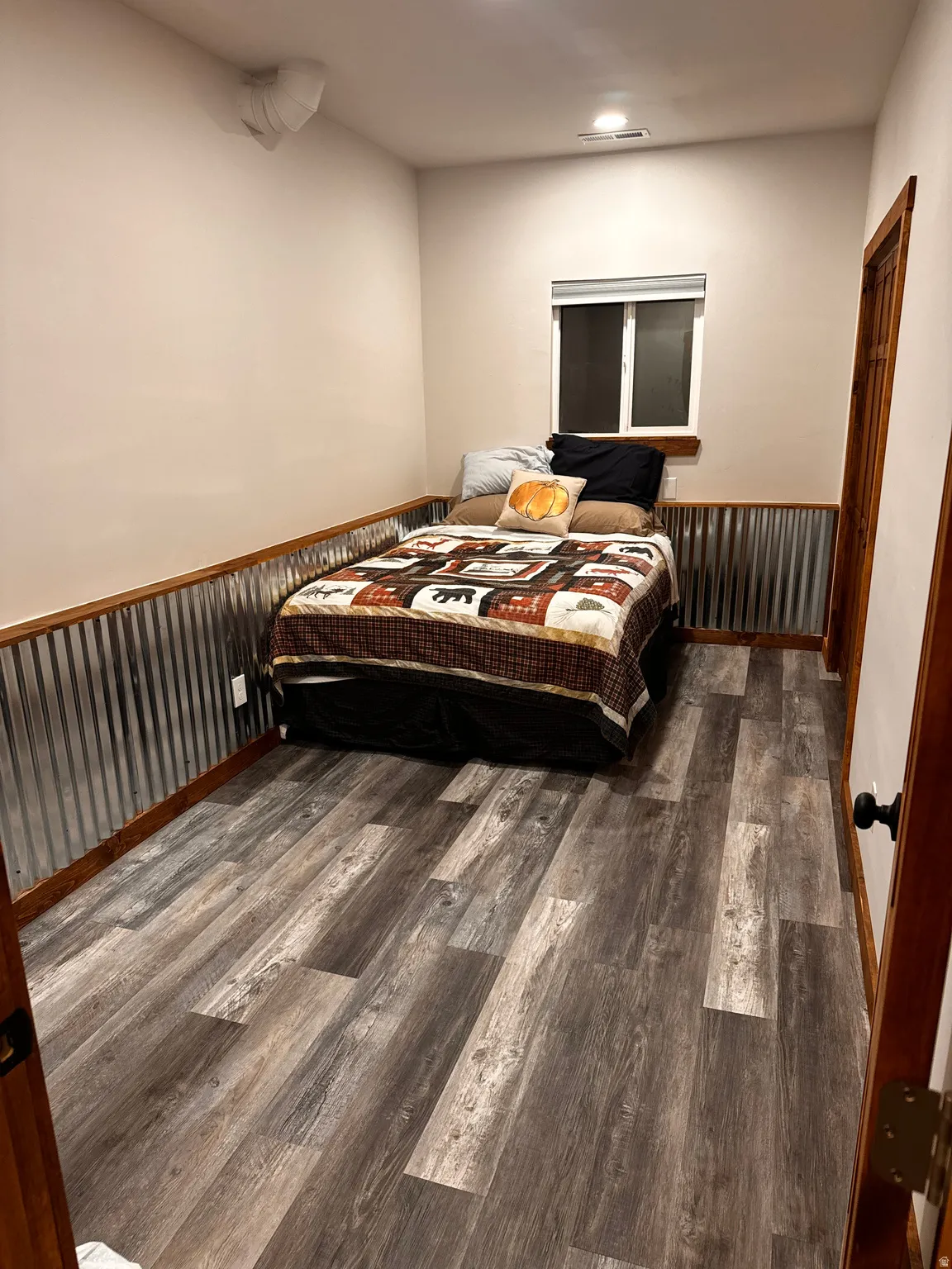Wood-finish flooring with corrugated metal wainscoting and wood trim