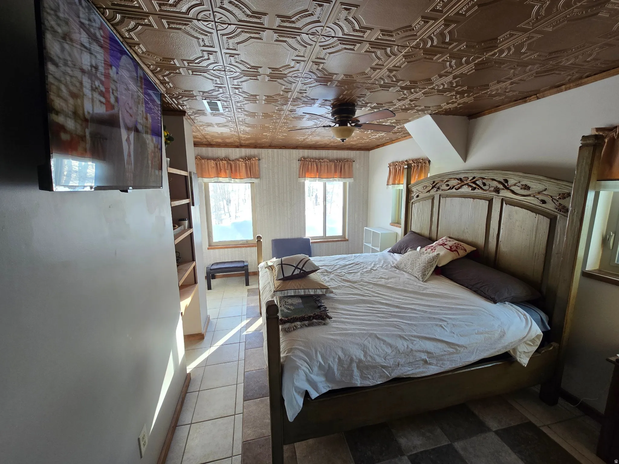 Decorative ceiling fan, built-in shelving, tiled flooring, wood-framed windows, and a decorative ceiling