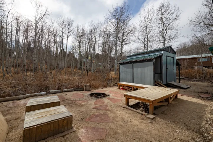 Outdoor area featuring a fire pit, flagstone patio, and a storage shed with a ramp entrance