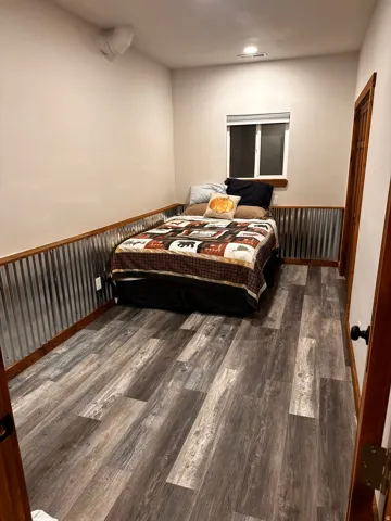 Wood-finish flooring with corrugated metal wainscoting and wood trim