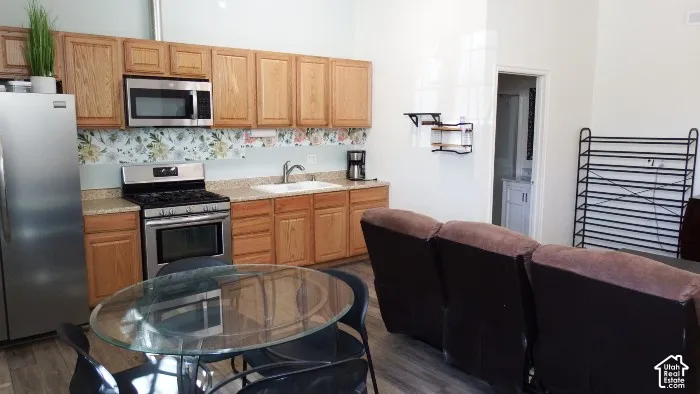 Kitchen with wood-finish cabinetry, stainless steel appliances, and a unique backsplash