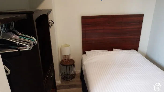 Wood-finish flooring with a dark wood-finish headboard
