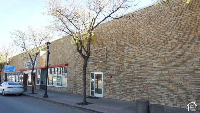 Stone facade building with multiple storefronts and large display windows