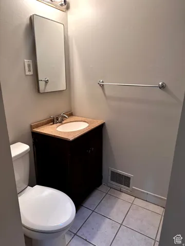Vanity with a neutral-toned countertop and an integrated sink, complemented by a wall-mounted mirror