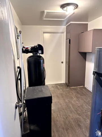 Wood-finish flooring with flush-mounted ceiling light fixture and overhead access panel