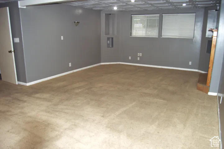 Interior room featuring wall-to-wall carpeting, a coffered ceiling, recessed lighting, and dual windows with horizontal blinds