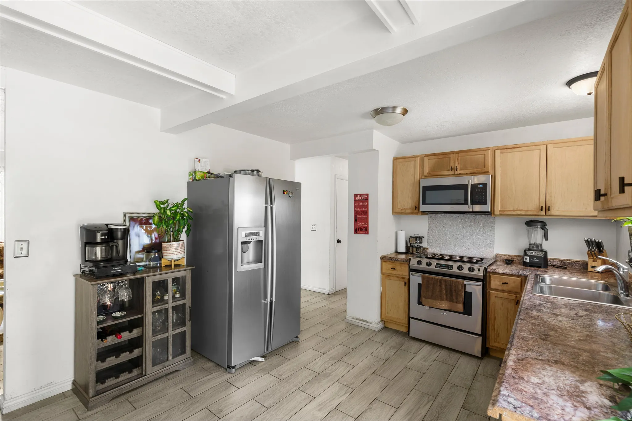 Kitchen featuring wood-finish cabinetry, stainless steel appliances, and a double basin sink