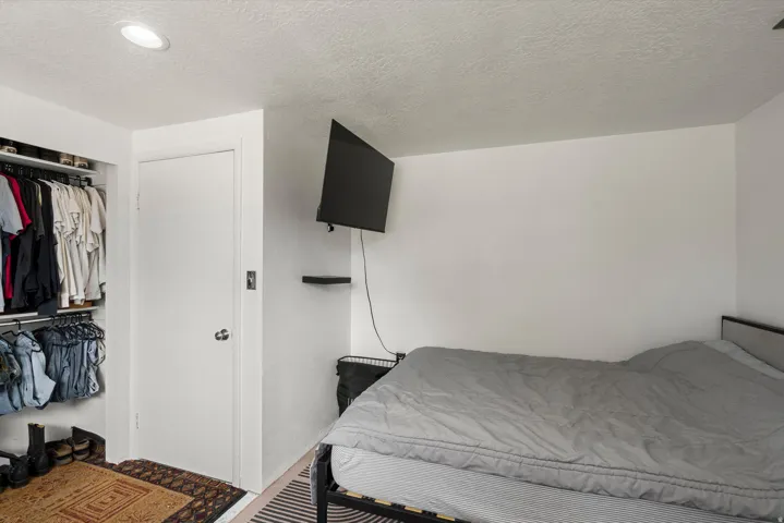 Recessed ceiling lighting, built-in closet with hanging rods, built-in wall shelving