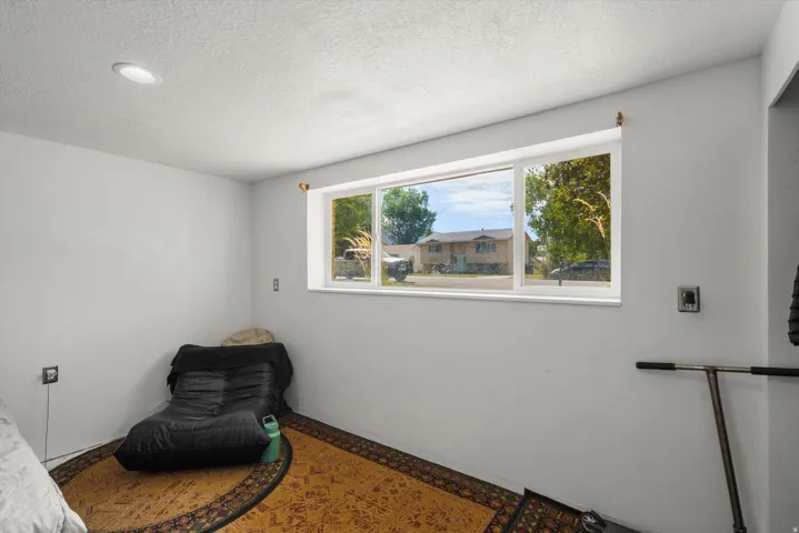 Recessed ceiling lighting, white walls, and a large window with white trim