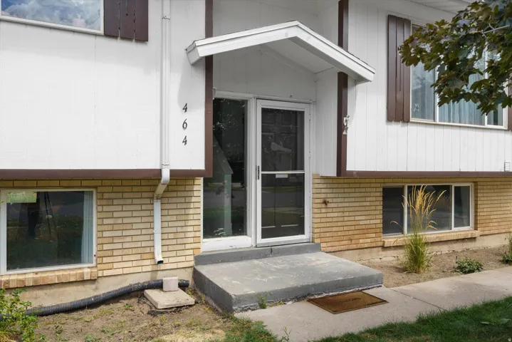 Split-level exterior featuring white siding and light brickwork