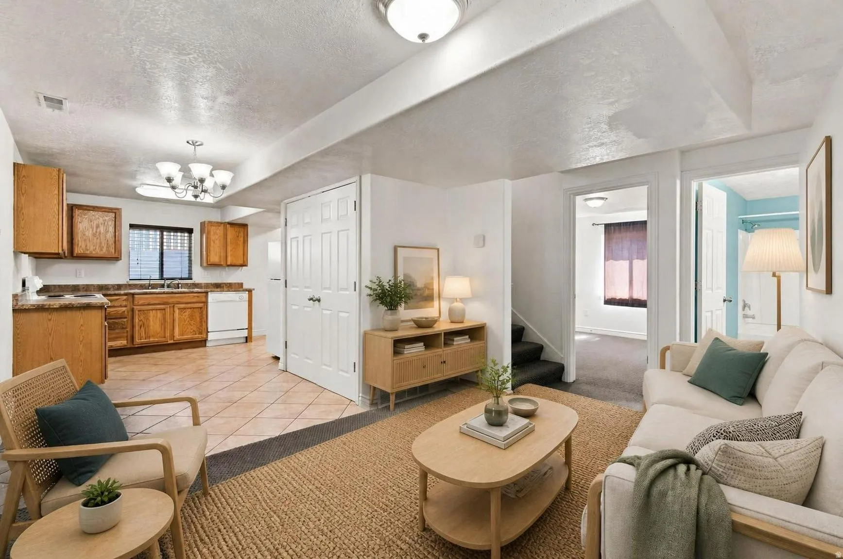 Open view of the downstairs living room, with the Kitchen to the left and the bath and Bedroom to the right. This picture has been virtually staged