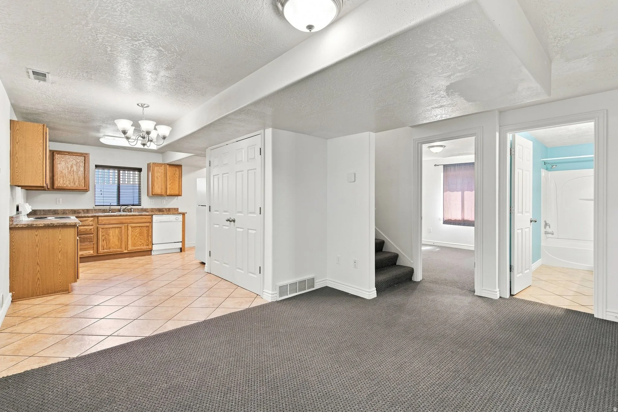 Open view of the downstairs living room, with the Kitchen to the left and the bath and Bedroom to the right.