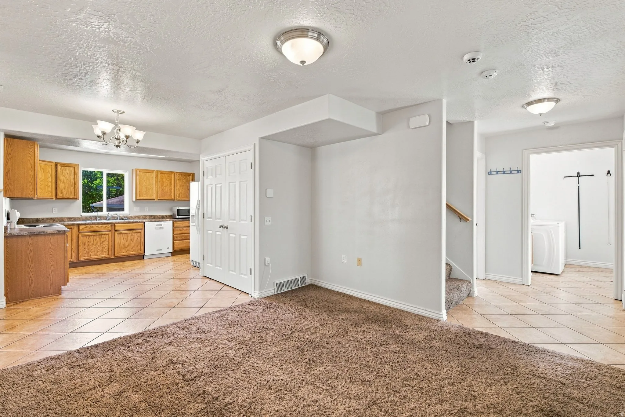 A different perspective of the main level: Entry, Living Room, Dining/Kitchen, and Laundry Room.
