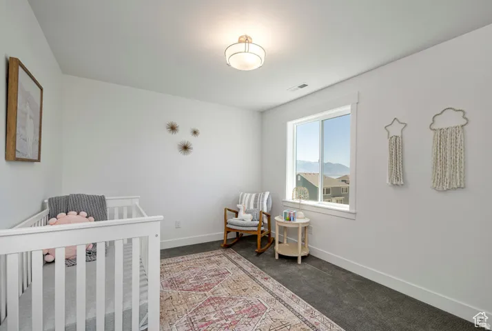 White walls complement the dark carpet flooring