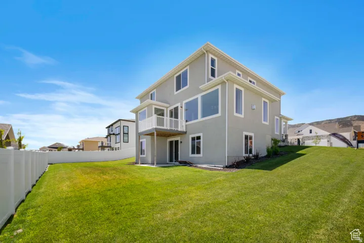 Contemporary exterior with stucco finish, multiple large windows, a raised white railing deck, a lower-level patio door, and a white privacy fence