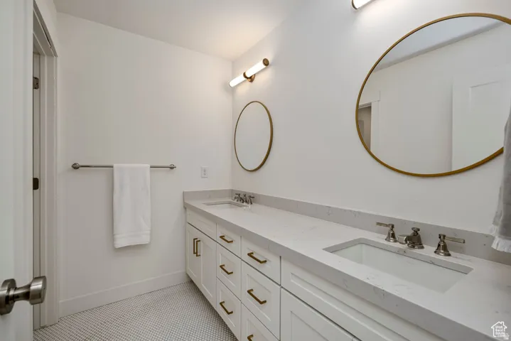 Dual vanity with white cabinetry and gold-toned hardware