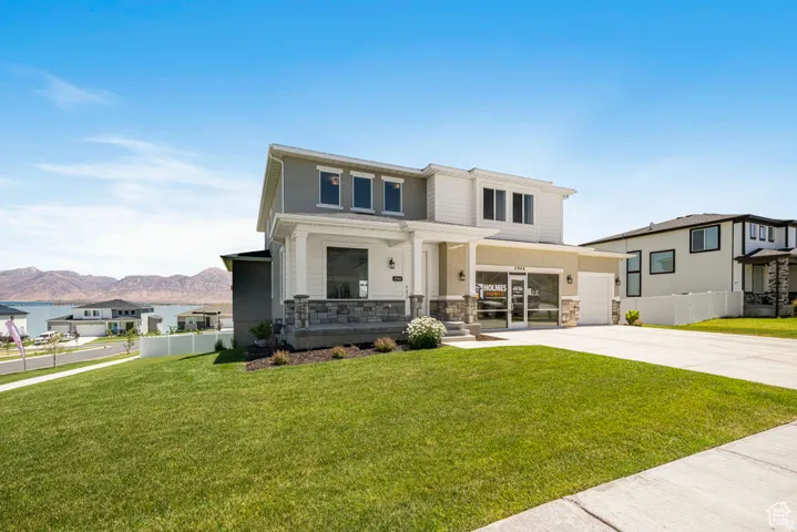 Contemporary two-story exterior with stone veneer accents, an attached two-car garage, and a covered front porch