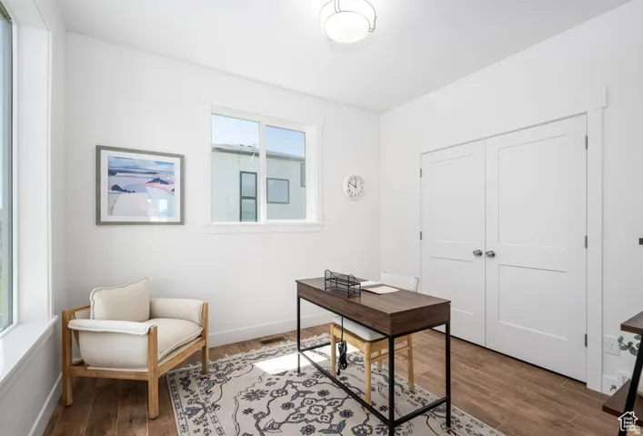 Wood-finish flooring, white walls, and a contemporary flush-mount ceiling light