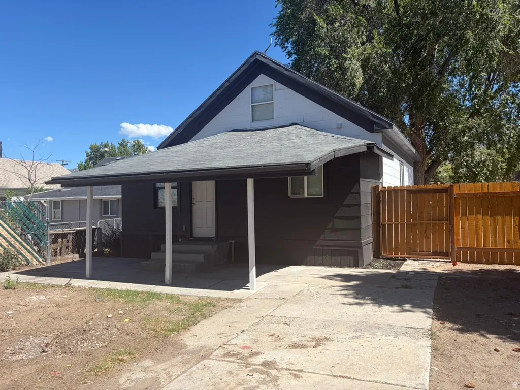 Exterior featuring an attached covered porch, concrete driveway, and a wood privacy fence