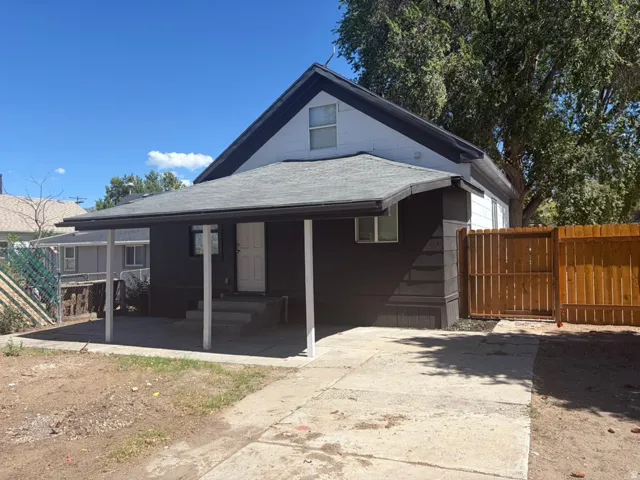 Exterior featuring an attached covered porch, concrete driveway, and a wood privacy fence