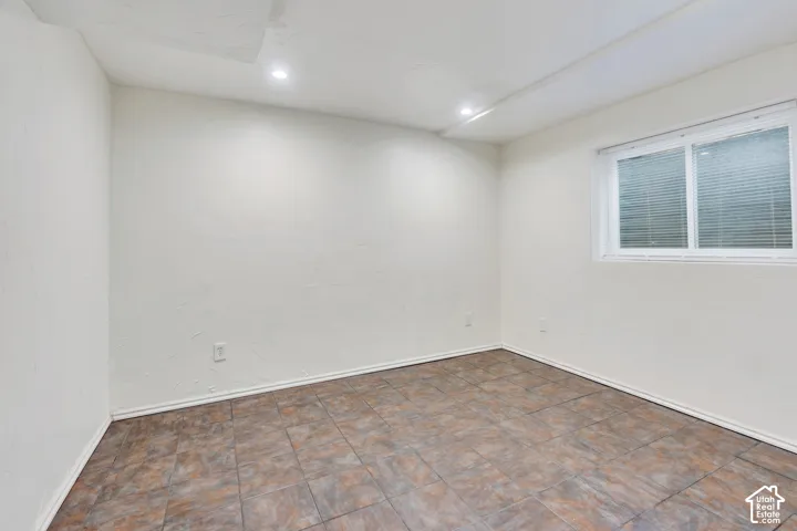 Interior space featuring tile flooring, smooth-finish walls, recessed lighting, and a horizontal sliding window