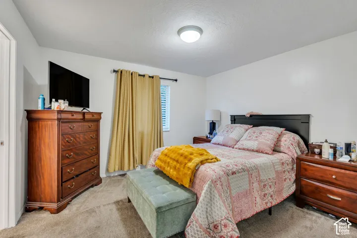Neutral-toned interior space featuring wall-to-wall carpeting and a ceiling-mounted light fixture