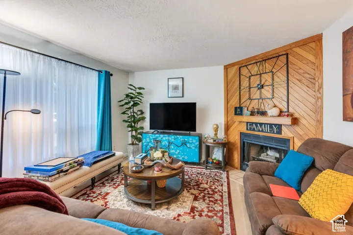 Living area featuring a fireplace with diagonal wood paneling and a wooden mantel
