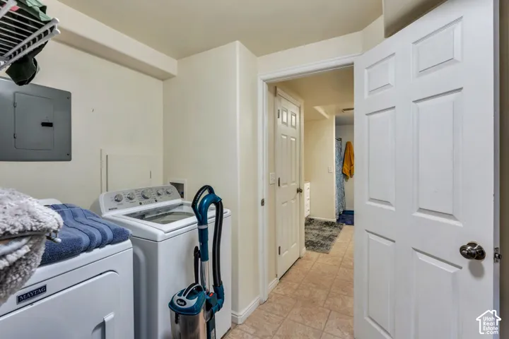 Utility space featuring tile flooring, six-panel interior doors, and a wall-mounted electrical panel
