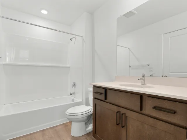 Contemporary bathroom featuring a tub/shower combination, recessed lighting, a vanity with a light-toned countertop, and wood-finish flooring