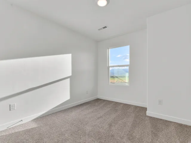 White walls with a single window, recessed lighting, and grey carpeting