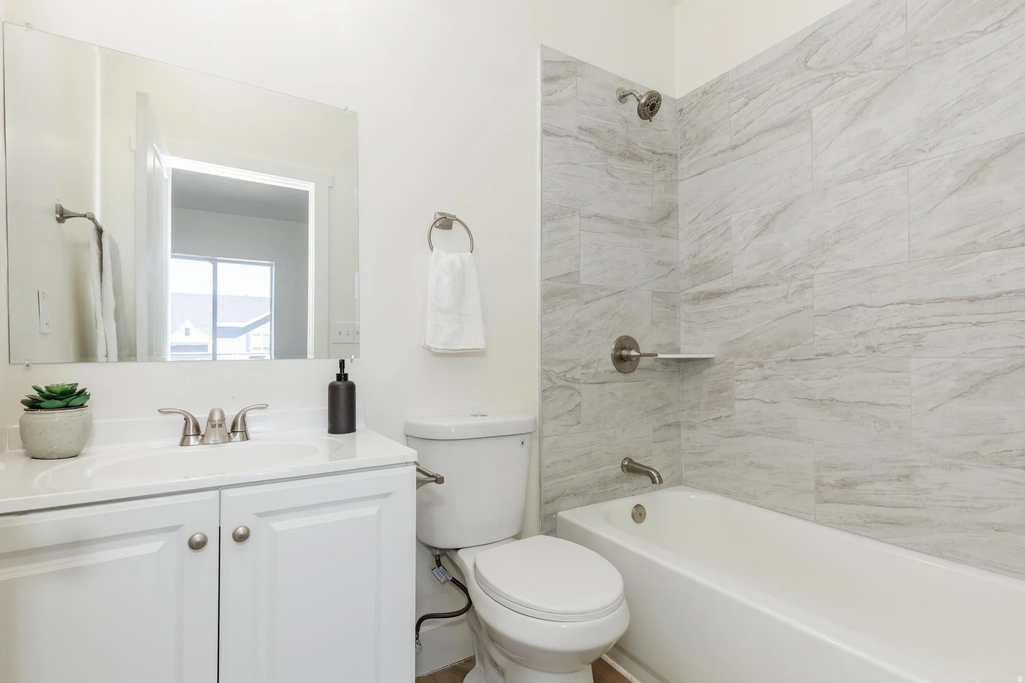 White vanity with dual cabinet doors, polished chrome faucet, and integrated sink