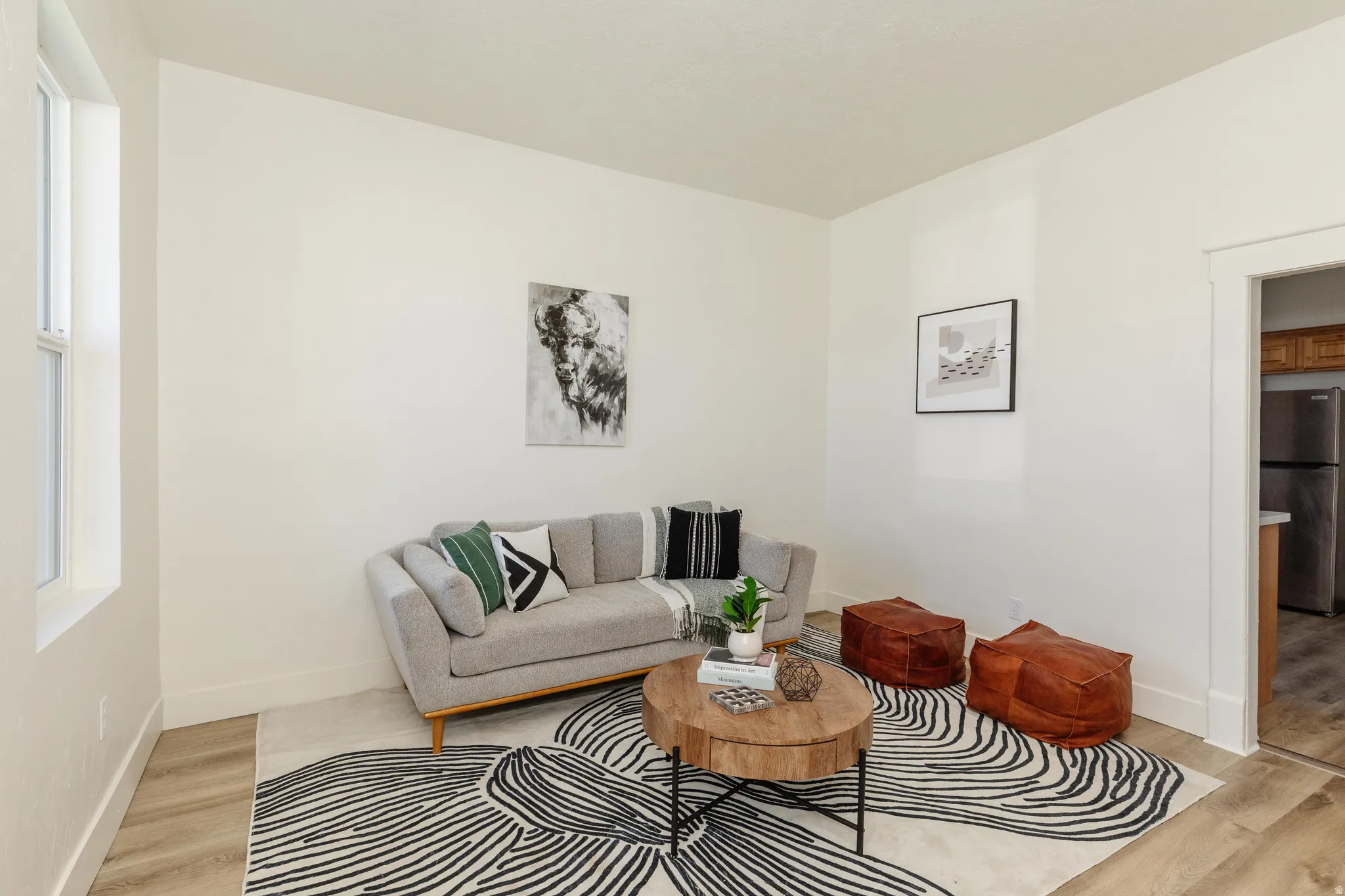 Neutral wall color, window with white trim, wood-finish flooring, and white door trim