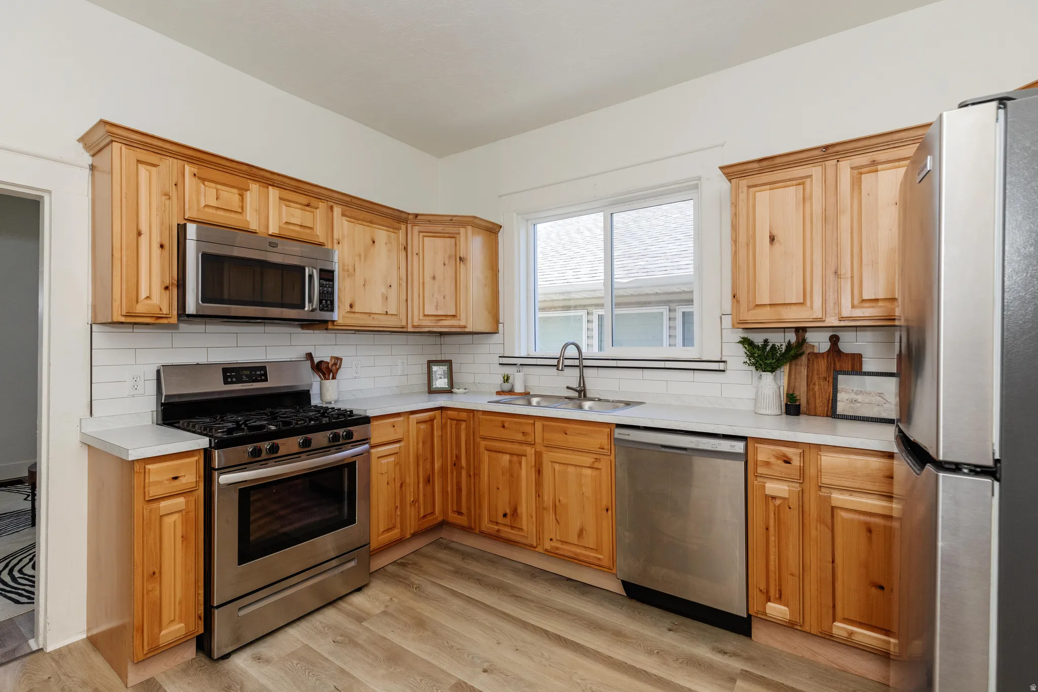 Wood-finish cabinetry paired with a subway tile backsplash and light countertops