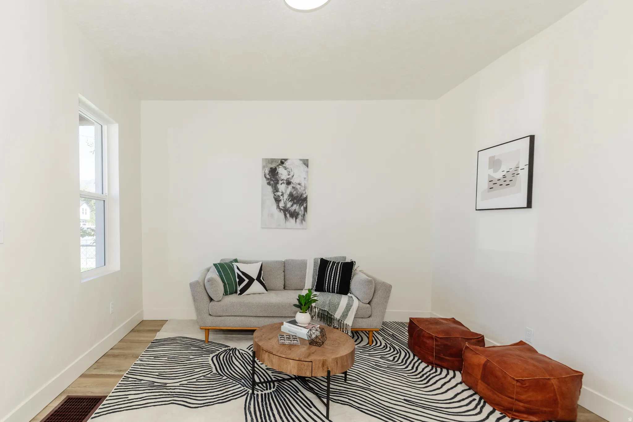 Light-toned walls, wood-finish flooring, and a single window offering natural illumination