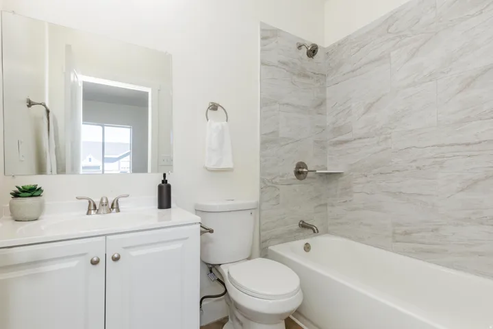 White vanity with dual cabinet doors, polished chrome faucet, and integrated sink