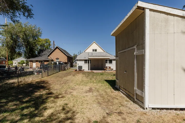 Rear yard featuring a detached storage shed and chain-link fencing